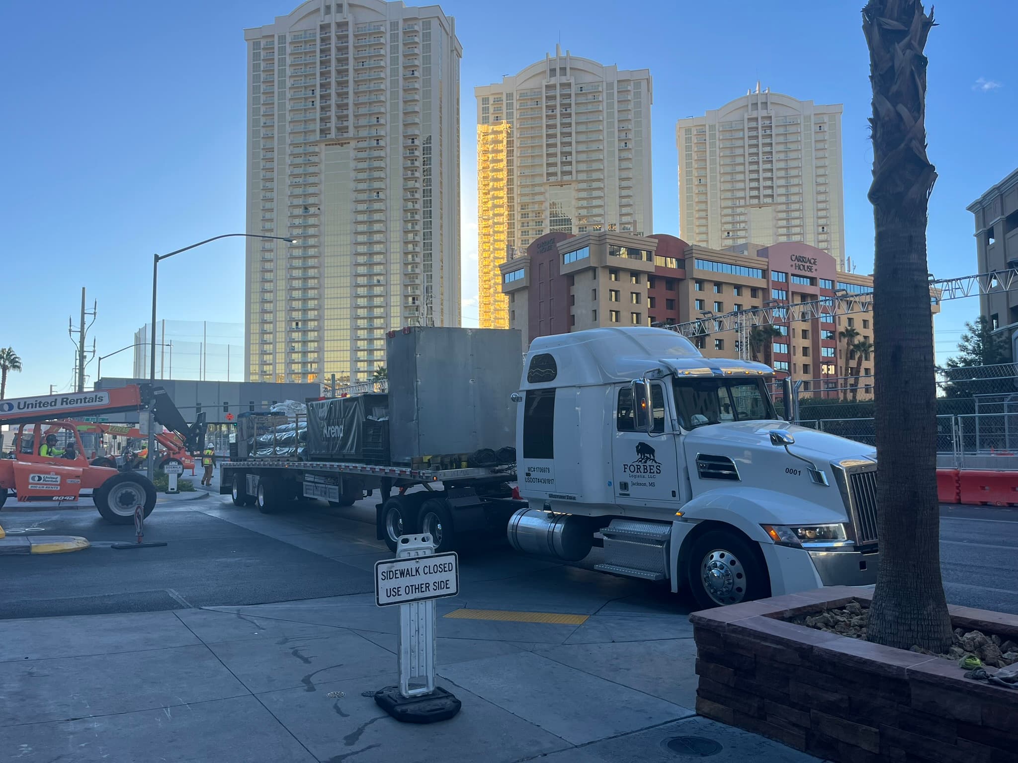 Forbes Logistix flatbed delivering freight in an urban jobsite